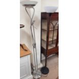 A steel standard lamp on a circular base together with a black painted standard lamp