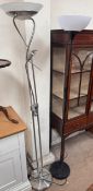 A steel standard lamp on a circular base together with a black painted standard lamp
