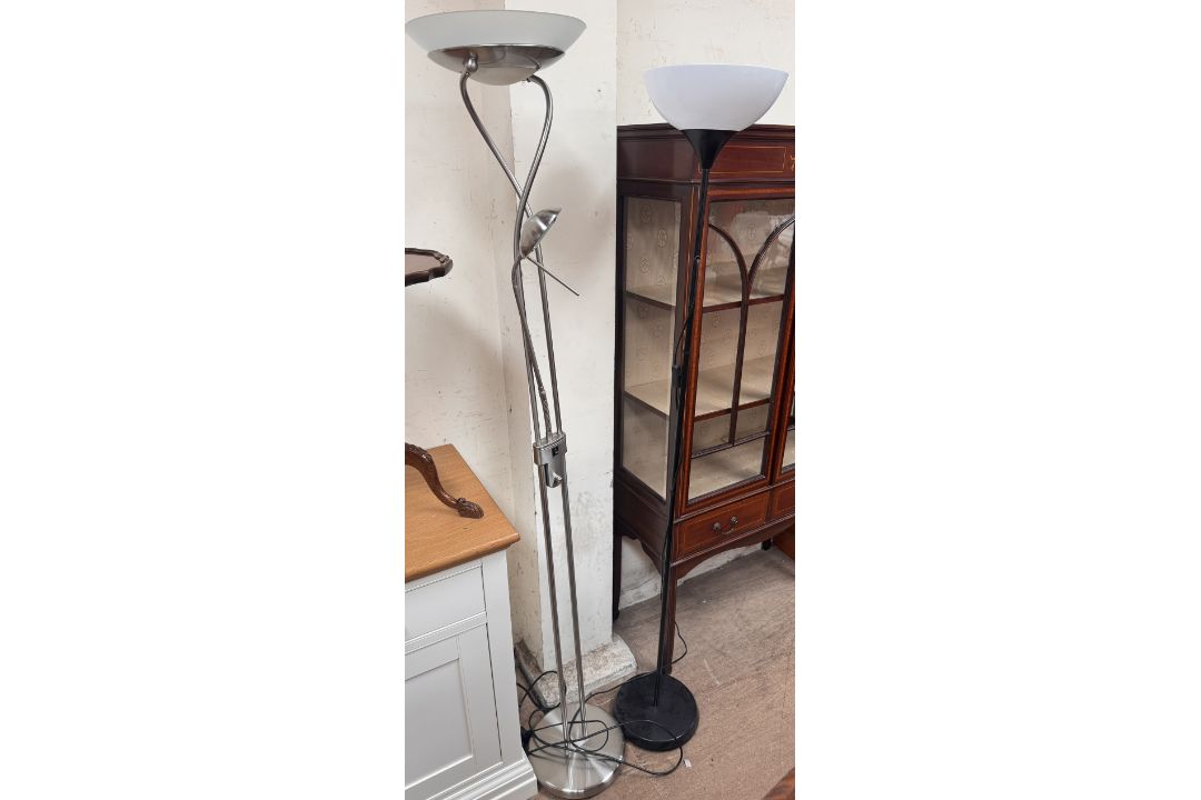 A steel standard lamp on a circular base together with a black painted standard lamp