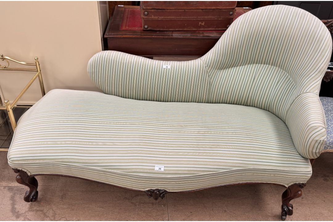 A Victorian walnut framed chaise longue with candy stipe upholstery on scrolling legs