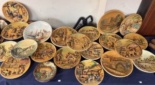 A large quantity of moulded plaster and pottery chargers depicting cottage scenes