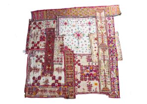 A GROUP OF NORTH INDIAN COTTON AND SHISHA EMBROIDERED CLOTH PANELS, WEDDING BELTS AND OTHERS (16)