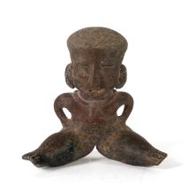 AN EARTHENWARE AND SLIP DECORATED SEATED FEMALE FERTILITY FIGURE