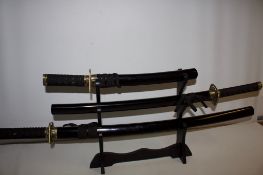 Pair of Japanese-style display swords (katana and wakizashi) with black lacquered saya, cord-wrapped