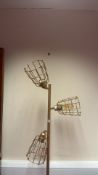 A three-light floor lamp with gold-tone metal column and circular base, each adjustable head