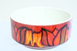 A Poole Pottery earthenware bowl, of rounded form with white interior and a red ground exterior