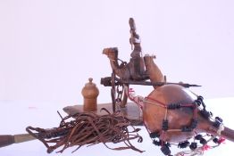 A group of rustic decorative objects comprising a carved wooden camel-and-rider tableau on an oval
