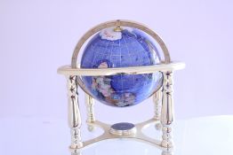 A blue-glass terrestrial globe with gilt latitude and longitude lines, mounted on a polished metal