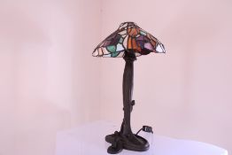 A Tiffany-style leaded stained-glass table lamp, the shade with floral panels in lilac, amber, green