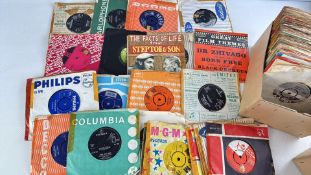A group of assorted 7-inch 45 rpm vinyl records in mixed label sleeves and record box