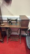 A Singer treadle sewing machine in oak cabinet with cast-iron stand