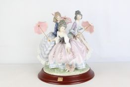 Lladro porcelain figural group three ladies with parasols and a small dog, modelled in pastel