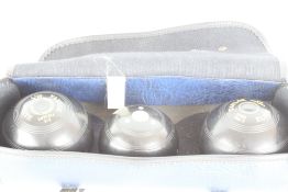 A group of Taylor Elite lawn bowls and jack in a carry case