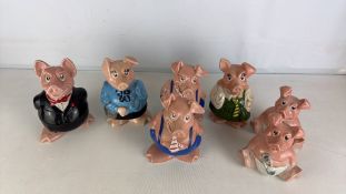 A group of Wade England pig figures in costume, glazed earthenware