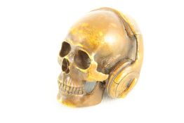 Bronze skull wearing headphones