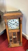 Oak cased wall clock with Roman numeral dial and pendulum