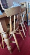 Rectangular pine dining table with two matching spindle-back chairs