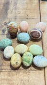 Ten polished hardstone eggs, one on stand
