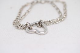 Silver bracelet with central heart shaped clasp We