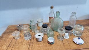 Six assorted glass vessels, including an embossed flask and pharmacy bottles