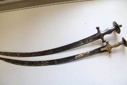 Two Middle Eastern 19th Century curved sabres with plain and gilt-engraved hilts