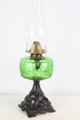 Green glass oil lamp with brass burner and cast metal base