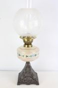 Decorative table oil lamp with painted milk-glass font and etched glass globe