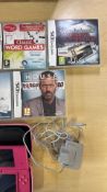 Pink Nintendo DS console with charger, case and assorted DS games