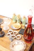 A quantity of decorative objects including ceramic figures, glasswares, napkin rings and boules set