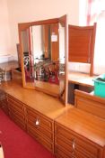 A Multi-Piece Bedroom Furniture Suite Comprising a Dresser with Mirror, Headboard, and Bedside Chest