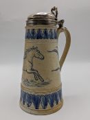A Doulton Lambeth salt glazed stoneware tankard with a silver domed lid, thumb piece and collar, the