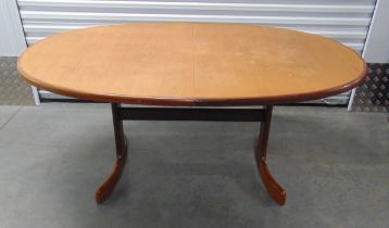 A mid 20th century G-Plan oval teak dining table with one drop in leaf on four outswept supports, 72