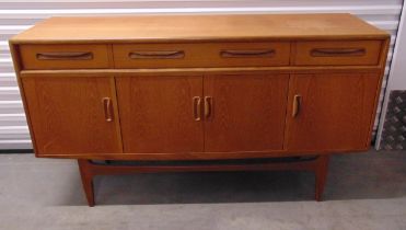 A mid 20th century rectangular teak sideboard with cupboards and drawers on four tapering
