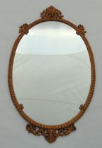 Gilt metal oval wall mirror with gadrooned border and applied putti, 63 x 37cm