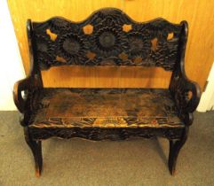 An ebonised rectangular wooden bench carved throughout with stylised leaves and flowers, 96 x 91 x