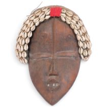 A West African Dan carved wood mask, Liberia/Ivory Coast, with shell-mounted textile mount, H28cm