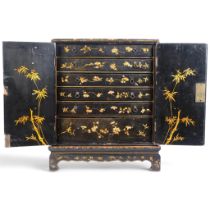 An early 19th century chinoiserie black lacquered and gilded table cabinet, 2 doors enclosing