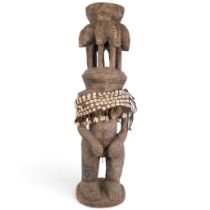A large West Africa carved wood multi-headed figure, with leather shell-mounted belt, H87cm