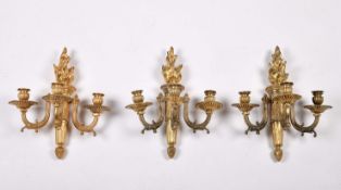 A set of three wall sconces with three light each