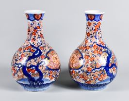 A Pair of Japanese Imari Porcelain Bottle Vases, decorated in blue, red and gilt with shaped