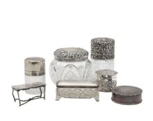 A collection of silver dressing table jars, and a German silver miniature table