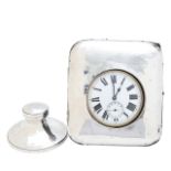 A pocket watch in a silver case and a silver inkwell