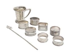 Seven silver napkin rings, a Christening mug, and a cocktail stirrer