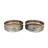A pair of silver wine coasters