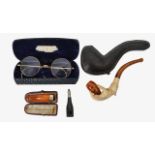 A meerschaum pipe, amber cheroot holder, gold plated spectacles and a cigar cutter