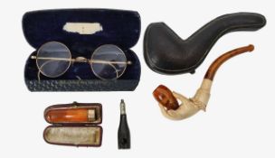 A meerschaum pipe, amber cheroot holder, gold plated spectacles and a cigar cutter