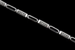 A 9ct white gold and diamond line bracelet