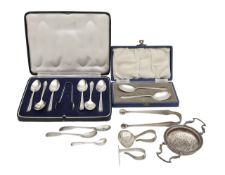 A collection of silver flatware and a tea strainer