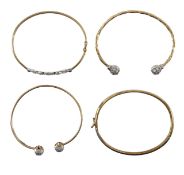 A group of four gold bangles
