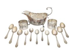 A George V silver sauceboat, napkin rings, and spoons